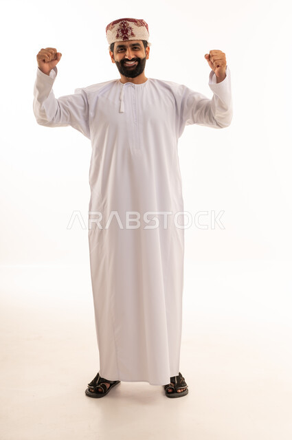 رجل عماني بالزي التقليدي يحتفل بالنجاح والنصر