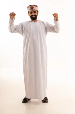 رجل عماني بالزي التقليدي يحتفل بالنجاح والنصر