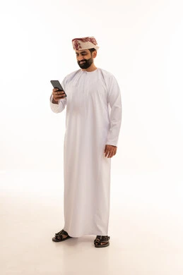 Omani Man in Traditional Dress Using Smartphone Studio