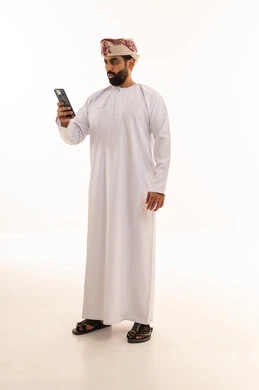 Omani Man in Traditional Dress Using Smartphone
