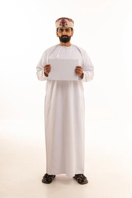 رجل عماني بالزي التقليدي يحمل لوحة بيضاء فارغة