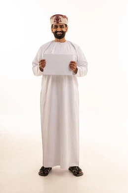 رجل عُماني بالزي التقليدي يحمل لوحة بيضاء فارغة