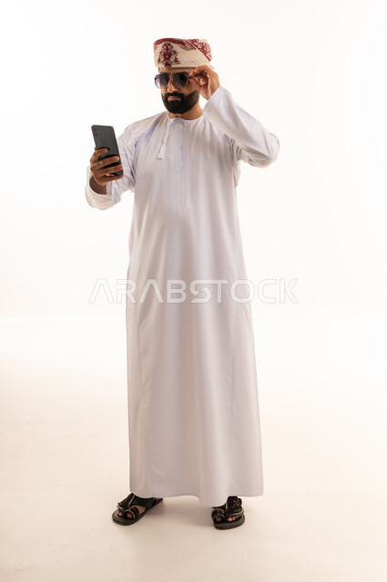 Omani Man in Traditional Dress with Smartphone