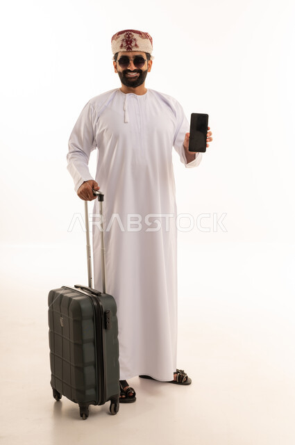 Omani Man with Suitcase and Smartphone in Studio