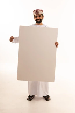 رجل عُماني يمسك لوحة بيضاء فارغة في الاستوديو