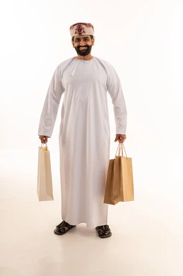 رجل عماني يحمل حقائب تسوق في الاستوديو