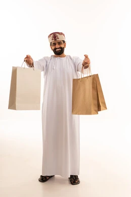 رجل عماني يحمل أكياس تسوق بخلفية بيضاء
