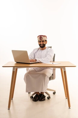 Omani Businessman Working on Laptop Desk White Background