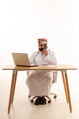 Omani Man Working on Laptop at Office Desk