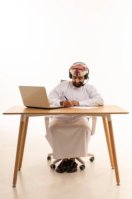 Omani Man in Traditional Dress Working on Laptop