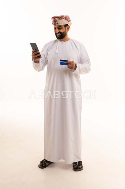 رجل عماني يتسوق عبر الإنترنت باستخدام بطاقة الائتمان