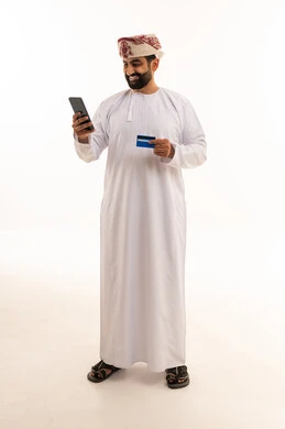 رجل عماني يتسوق عبر الإنترنت باستخدام بطاقة الائتمان