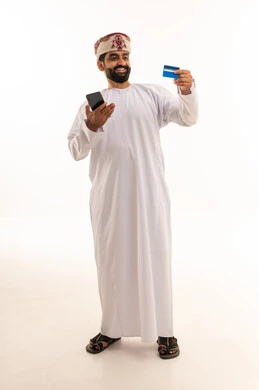 رجل عُماني مع بطاقة ائتمانية وهاتف ذكي للدفع