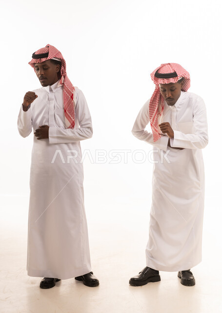 رجال سعوديون بالثوب التقليدي في وضعية السعال