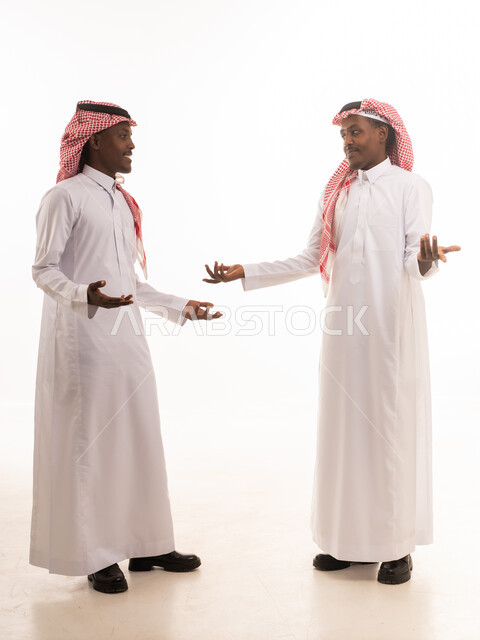 رجلان سعوديان بالزي التقليدي يتحدثان معاً