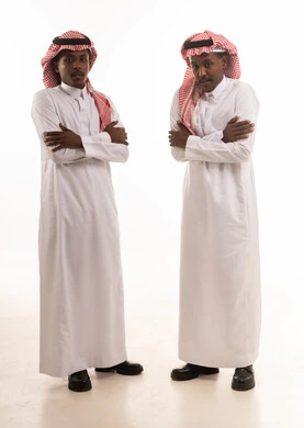 رجلان سعوديان بالثوب التقليدي في استوديو بخلفية بيضاء