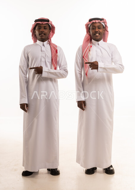 رجلان سعوديان بالزي التقليدي يشيران في الاستوديو