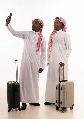 رجلان سعوديان مع حقائب سفر يلتقطان سيلفي