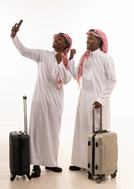 رجال سعوديون مع حقائب سفر يلتقطون سيلفي خلفية بيضاء