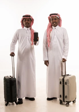 رجال سعوديون مع حقائب سفر وهاتف ذكي