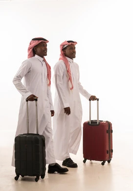 رجال سعوديون بالزي التقليدي مع حقائب سفر
