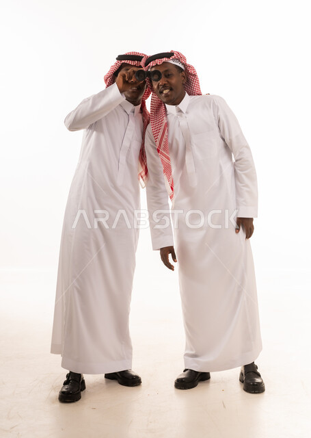 رجال سعوديون بالزي التقليدي يستخدمون المنظار