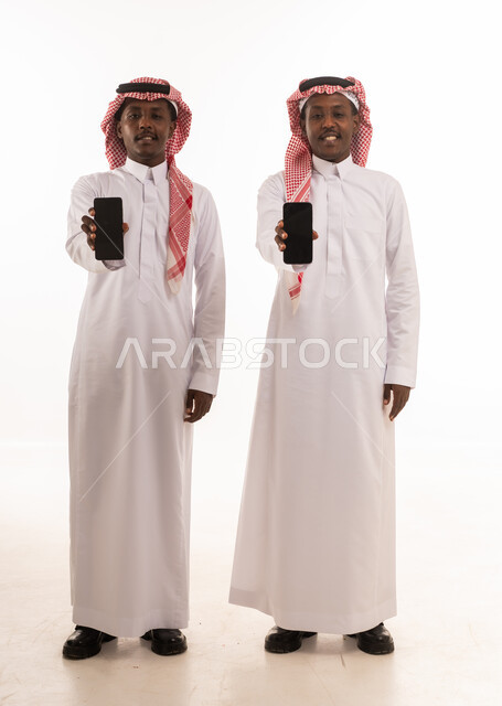 Two Saudi Men Holding Smartphones on White Background