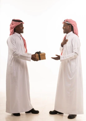 رجلان سعوديان يتبادلان الهدايا بالزي التقليدي