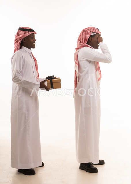 رجل سعودي بزي تقليدي يقدم مفاجأة لصديقه