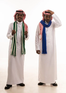 رجال سعوديون بالثوب التقليدي مع إيماءات النصر والخسارة