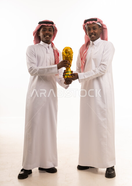 رجال سعوديون يحملون كأس العالم في الاستوديو