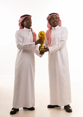 Saudi Men Holding Gold Trophy in Traditional Thobe