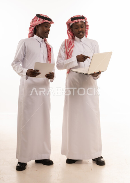 رجال أعمال سعوديون يناقشون العمل على لابتوب