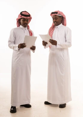 Saudi Men in Traditional Thobes Reviewing Documents