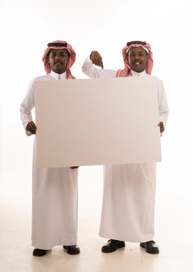رجلان سعوديان بالزي التقليدي يحملان لوحة بيضاء فارغة رجلان سعوديان بالزي التقليدي يحملان لوحة بيضاء فارغة