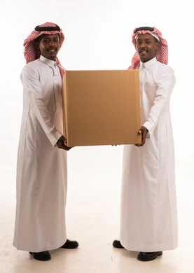 رجلان سعوديان يحملان صندوق شحن في الاستوديو