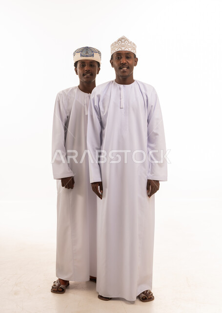 Two Omani Men in Traditional Dishdasha and Kumma Caps