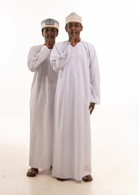 Omani Men in Traditional Dress with Silence Gesture