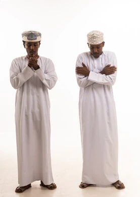 Omani Men in Traditional Dishdasha and Kumma Caps