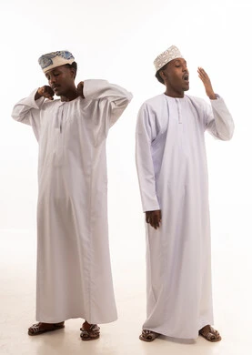 رجال عمانيون بالدشداشة التقليدية على خلفية بيضاء