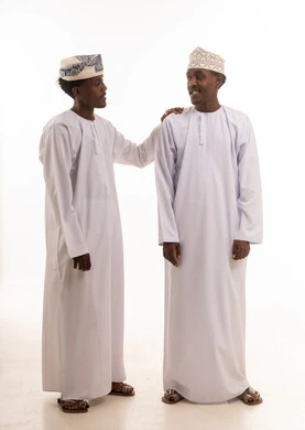 رجلان عمانيان بالزي التقليدي أمام خلفية بيضاء
