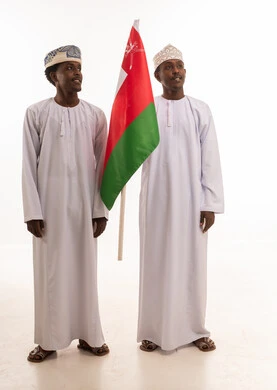 رجال بزي عُماني تقليدي يحملون علم سلطنة عُمان