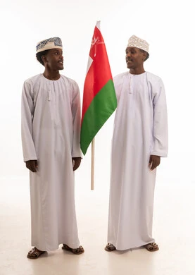 رجال عمانيون يحملون علم سلطنة عمان في استوديو تصوير