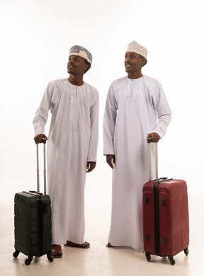 رجلان عمانيان مع حقائب سفر على خلفية بيضاء