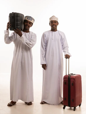 رجال عمانيون مع حقائب سفر على خلفية بيضاء