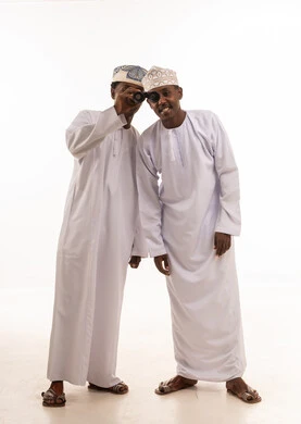 رجال عمانيون بالزي التقليدي ينظرون عبر المنظار