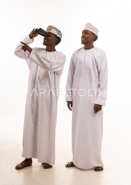 Omani Men in Traditional Dress Using Binoculars