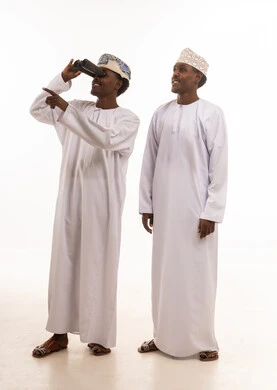 Omani Men in Traditional Dress Using Binoculars