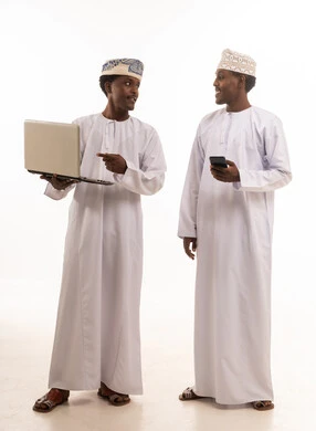 رجال عمانيون يستخدمون اللابتوب والهاتف في استوديو