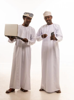 Omani Men Using Laptop and Smartphone on White Background